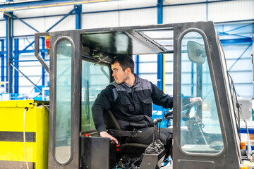 Worker driving a forklift in a factory