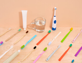 Pattern of colorful toothbrushes. Refreshing toothpaste and a cup of water.