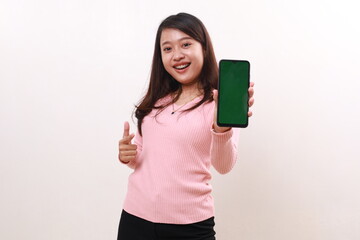 Happy young asian girl showing a blank cell phone screen, selective focus on phone. Isolated on white background