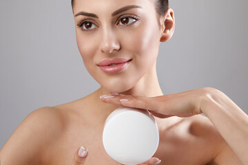 Skin care. Beauty Concept. Young woman holding cosmetic moisturizing cream. Soft skin and naked...
