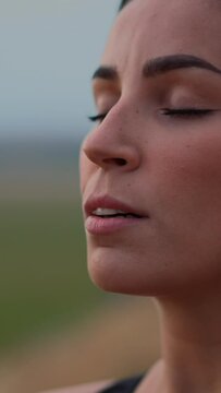 Head shot portrait of young peaceful woman breathing fresh air, enjoying deep meditation with closed eyes