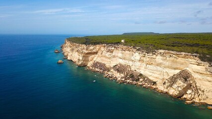 aerial view from the Atlantic Ocean towards the huge cliffs in the  Parque Natural de la Breña y Marismas de Barbate nature reserve and the Torre del Tajo historical watchtower, Costa de la Luz, Spain