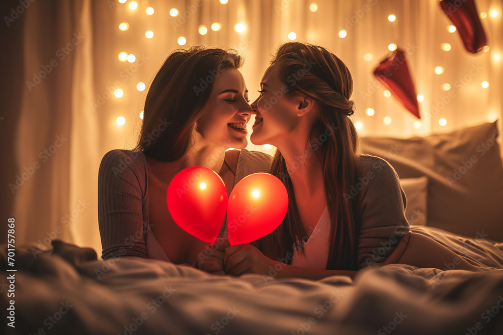 Wall mural women kissing and holding two balloons which create a  heart.