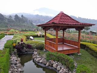 garden scenery in a rural valley with wooden gazebo