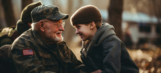 Fototapeta premium Elderly veteran sharing moment with young boy outdoors. Generational connection. Banner.
