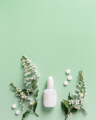 Seasonal allergy concept, spring blooming branches tree and mock up nasal spray white bottle, pills...