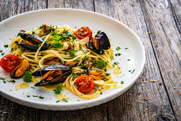 Noodles with mussels on wooden table
