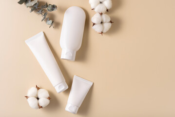 Blank white cosmetics tube on the beige background