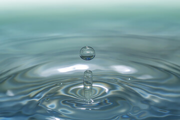 Clear aqua water droplet splashing in concentric circles, capturing refreshing purity.