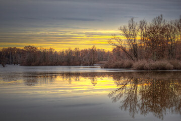A winter evening on Horseshoe Lake. Patches of thin ice on the surface.  Bare trees on the horizon....
