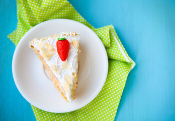 Piece of carrot cake with icing and little carrot