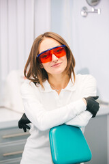 Portrait of a female dentist looking at the camera in the interior of a modern dental clinic. The concept of professional dentists and beautiful teeth.