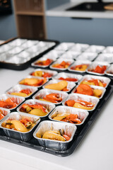 Pre-portioned Gourmet Roasted Bell Peppers in Trays. Close-up view of vibrant roasted bell peppers portioned in aluminum trays, prepared for a catered event or meal service.
