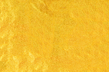Gold foil texture background with highlights and uneven surface