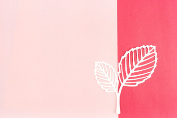 Carve of white paper leaves on a pink color background.