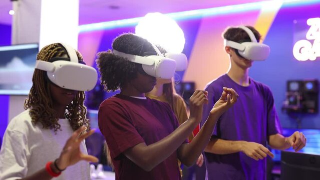 group of multicultural gamer friends with virtual reality glasses playing online video games with backlight and neons
