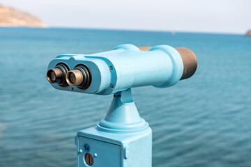 Coin operated binocular looking to the sea and Spinalonga Island on Crete, Greece.
