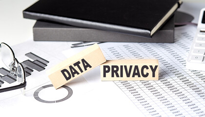 DATA PRIVACY - text on a wooden block with chart and notebook