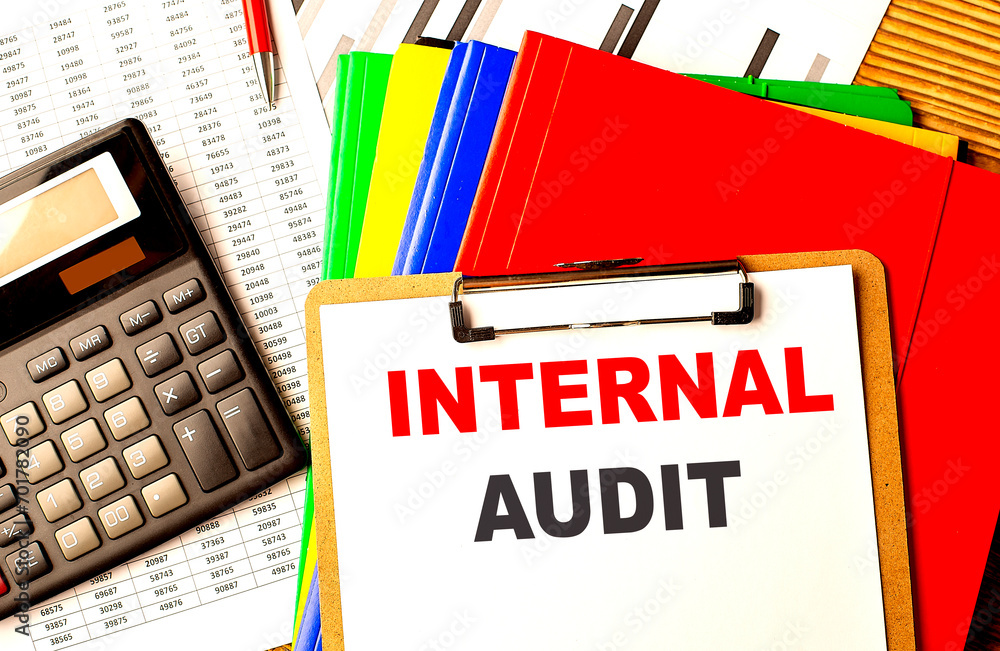 Poster internal audit text written on paper clipboard with chart and calculator