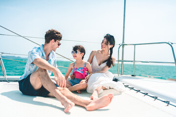 Happy carefree family travel adventures for young parents with daughter relaxing on luxury yacht at...
