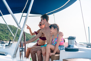 Happy carefree family travel adventures for young parents with daughter relaxing on luxury yacht at...