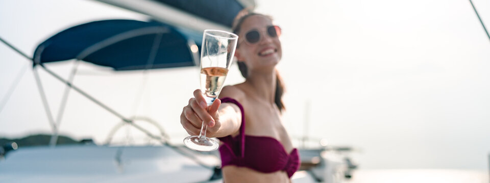Young woman drink a champagne at outdoor party on yacht. Attractive young women hanging out, happy fun to celebrating holiday vacation trip on catamaran sailing boat, Summer relaxation time
