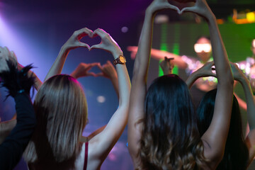 Close up hand love or mini heart. Nightlife and disco dance party concept. Sexy woman people and friends dancing in night club. music festival. Cheerful Happy fun Asian people dance in night club
