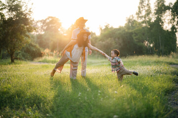 happy harmonious Asian family outdoors concept, Asian mother and son have activities happy fun together on holidays, grass land with sunlight - obrazy, fototapety, plakaty