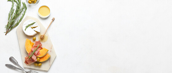 Tasty melon with prosciutto, cheese, olives and honey on light background with space for text