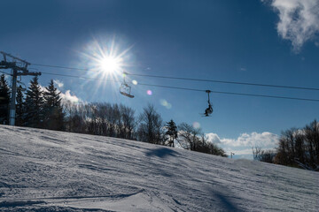 Ski lift with sunburst on winter day