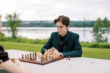 A lovely LGBT couple playing a chess game outdoors. 
