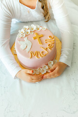 In the hands of a girl there is a birthday cake, a first communion cake, a baptism cake with...