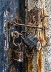 latches and padlocks on an old dilapidated door