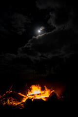 View of a camp fire with a glimpse of the half moon in Mauritius island