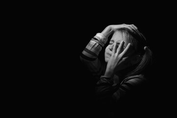 Conceptual imge: loneliness, pain, depression, child tragedy. Crying depressed young girl. Close up portrait. Black and white image. Copy space.