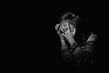 Conceptual imge: loneliness, pain, depression, child tragedy. Crying depressed young girl. Close up portrait. Black and white image. Copy space for design or text. - obrazy, fototapety, plakaty