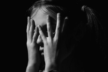 Close up portrait of crying young girl. Loneliness, depression, pain, child tragedy. Black and white image. Horizontal image.