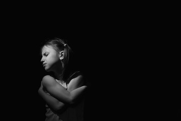 Portrait of crying young girl. Loneliness, pain, child tragedy. Black and white image. Horizontal image.