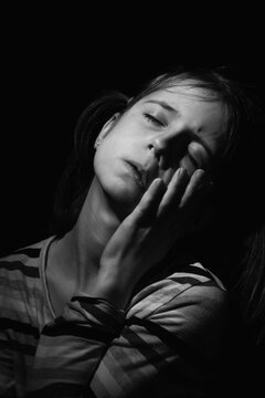 Portrait of crying young girl. Loneliness, pain, child tragedy. Black and white image. Vertical image.