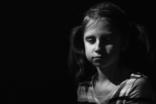 Portrait of crying young girl. Loneliness, depression, pain, child tragedy. Black and white image. Horizontal image. Copy space.