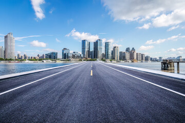 Empty asphalt road and city buildings skyline
