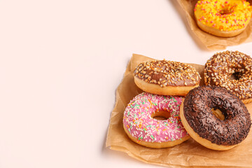 Paper bags with sweet donuts on white background