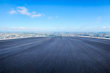 Fototapeta premium Motion blurred asphalt road and city skyline