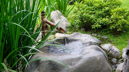 Rustic zen japanese bamboo water fountain in a garden