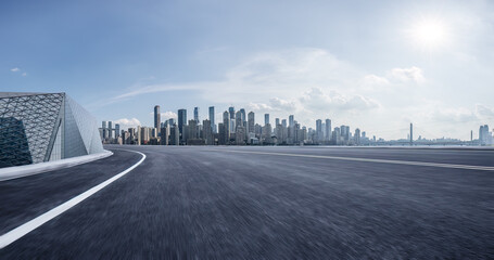 Obraz premium Motion blurred asphalt road and city skyline