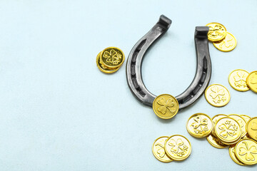 Horseshoe with golden coins on light background. St. Patrick's Day celebration
