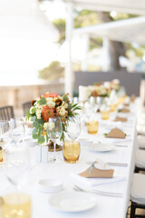 Long table set with bouquets of flowers and invitation succulents