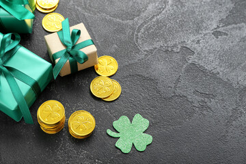 Gifts with golden coins and paper clover on black grunge background. St. Patrick's Day celebration