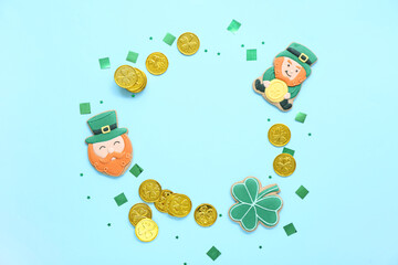 Frame made of golden coins, tasty decorative gingerbread cookies and sequins on blue background. St. Patrick's Day celebration