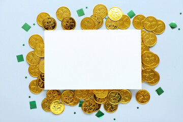 Blank card with golden coins and sequins on light background. St. Patrick's Day celebration